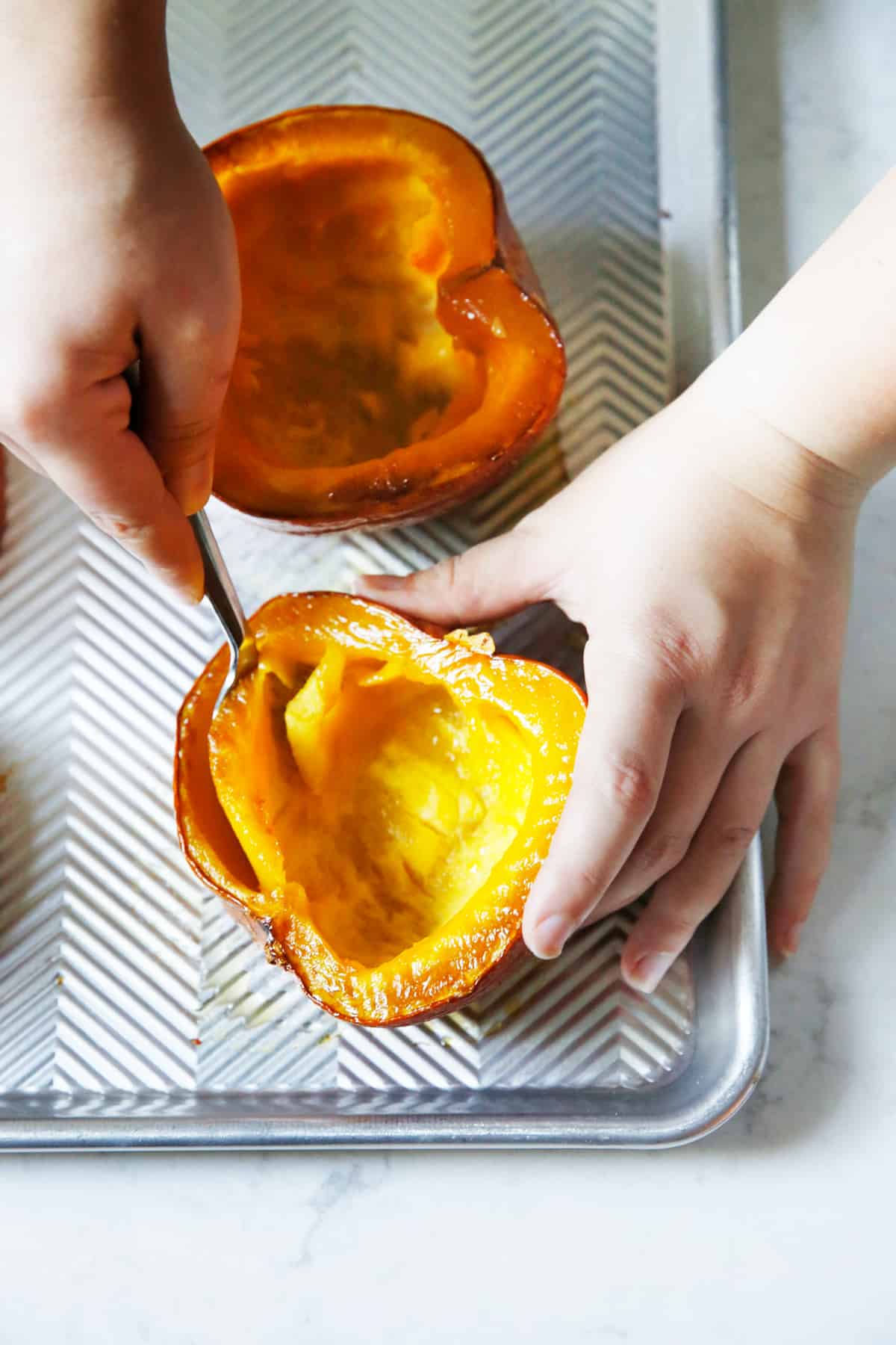 scooping out roasted pumpkin with a spoon