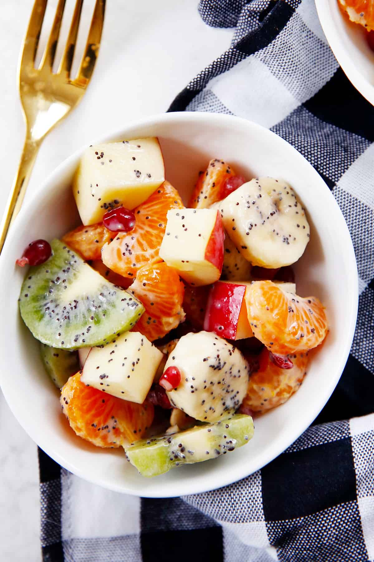 A bowl of winter fruit salad with poppy seeds and greek yogurt.