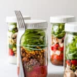 Mason jar salads with a fork attached to it.