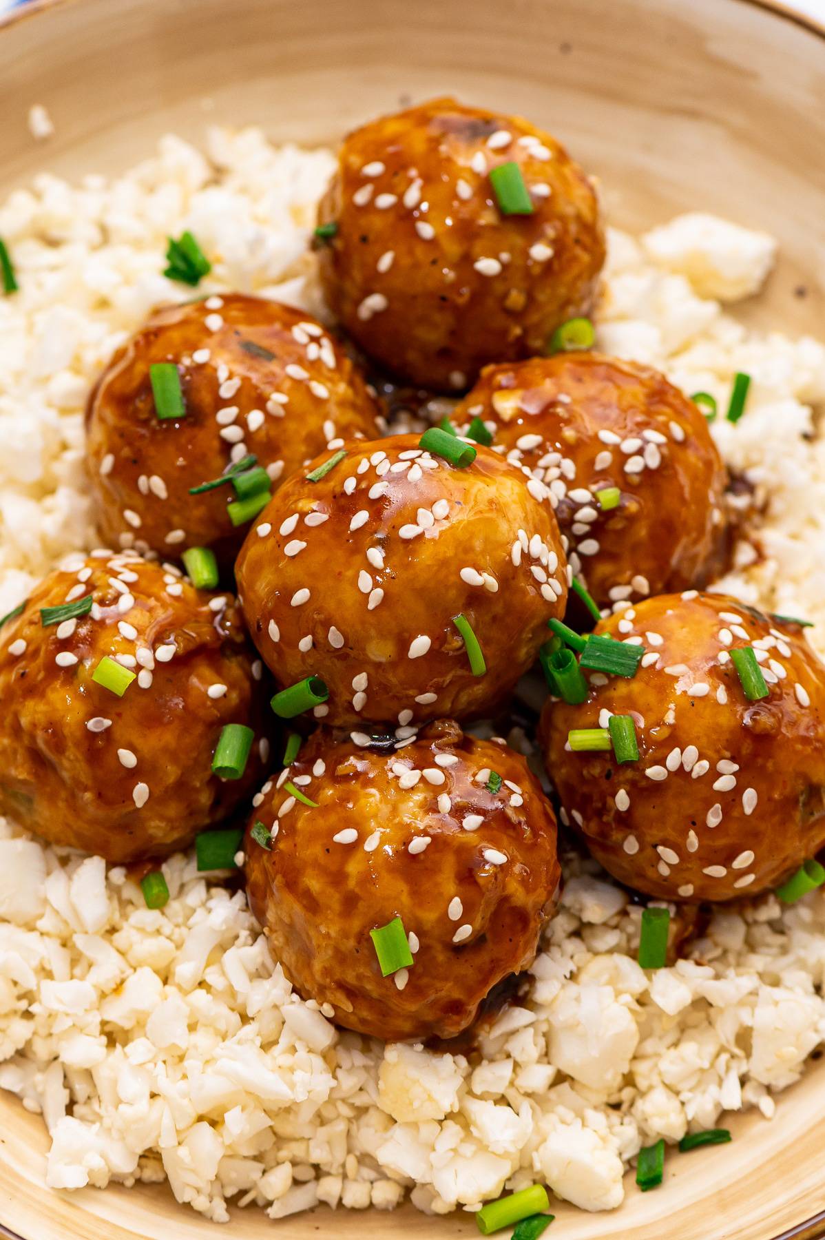 Sesame asian meatballs in a bowl with cauliflower rice.