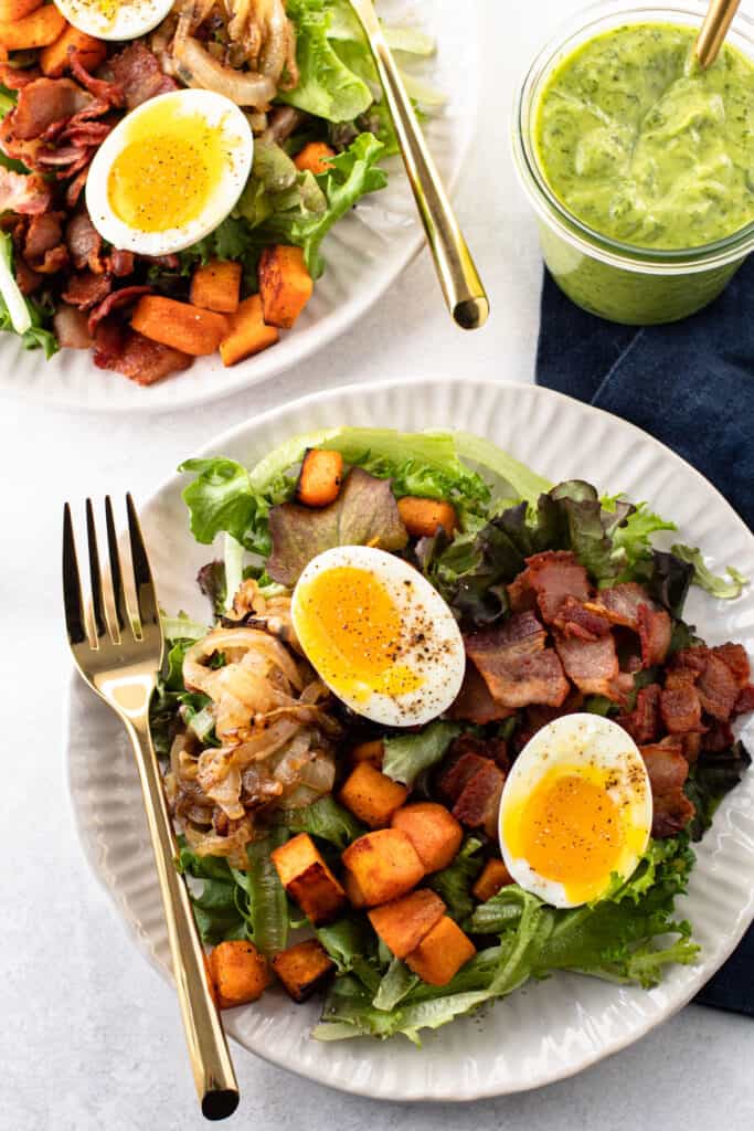 Breakfast salad with soft-boiled eggs, bacon, potatoes and onions.