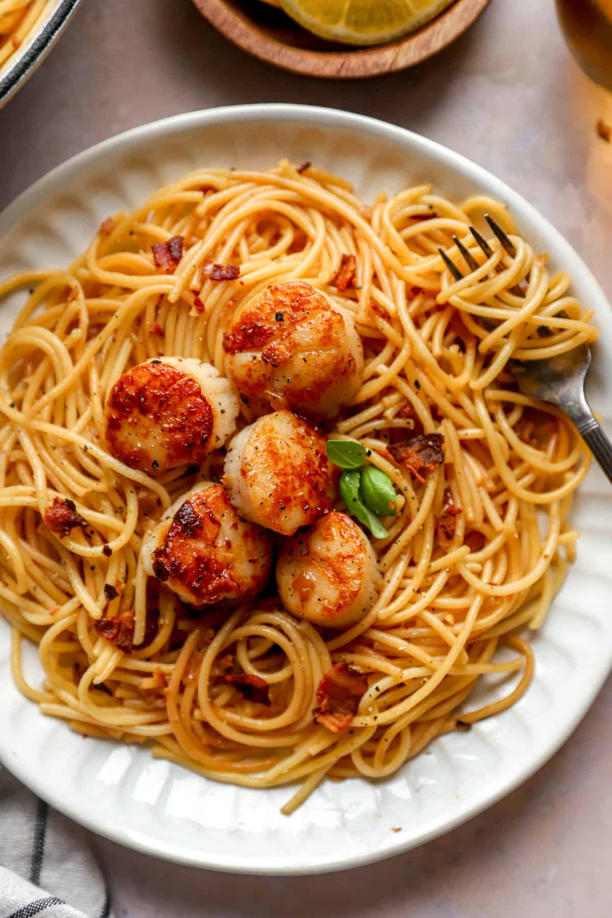 overhead of a plate of seared scallops with pasta.