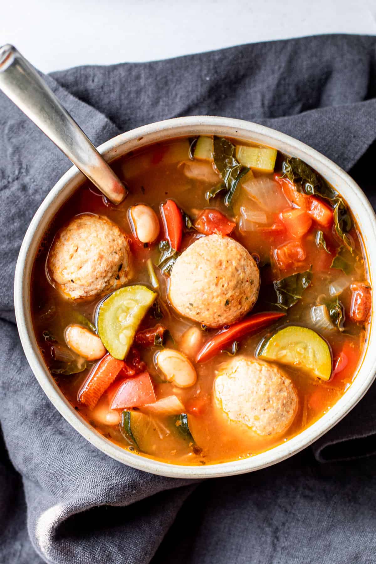 A bowl of meatball and veggie soup.