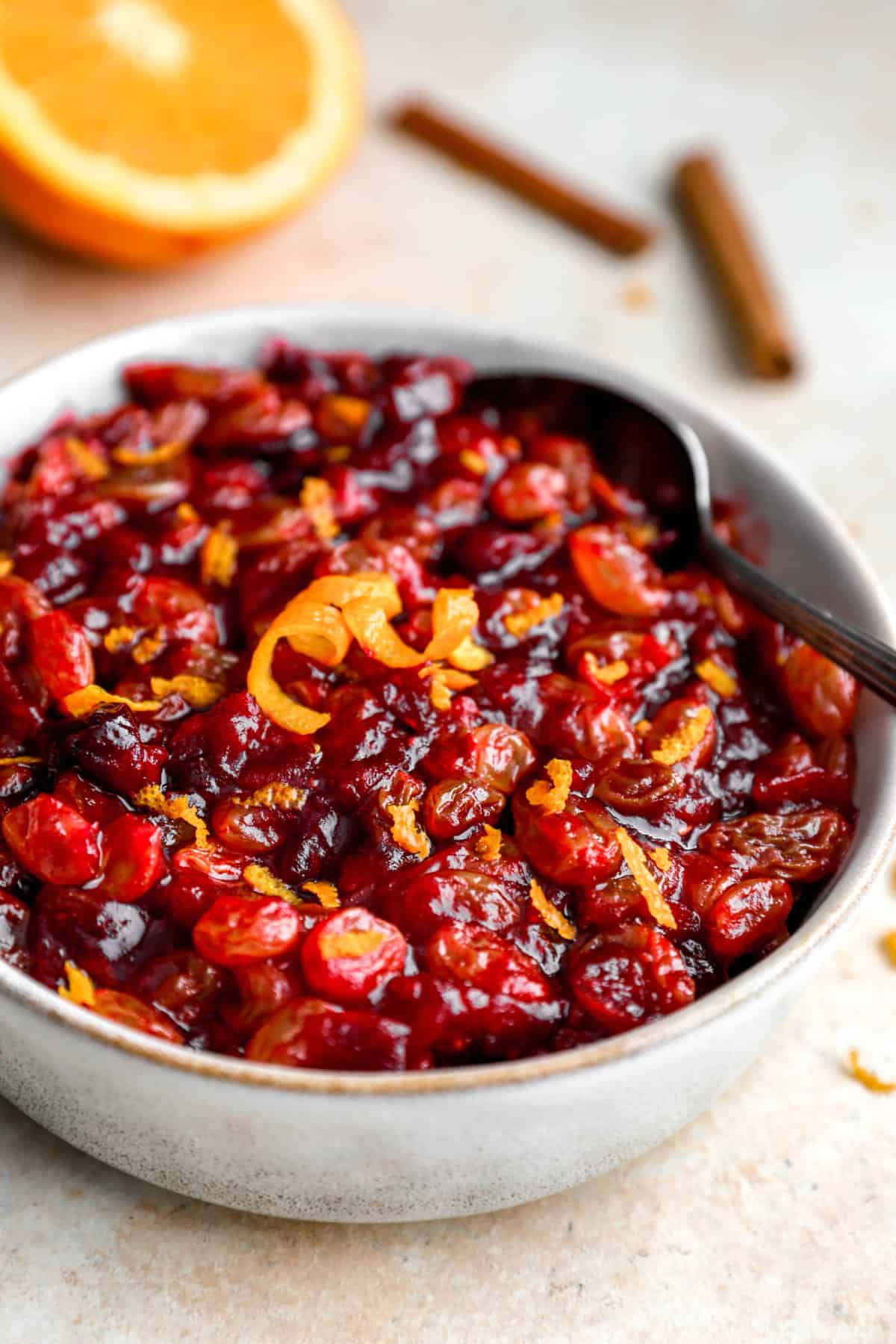 a bowl filled with cranberry relish topped with orange peel.
