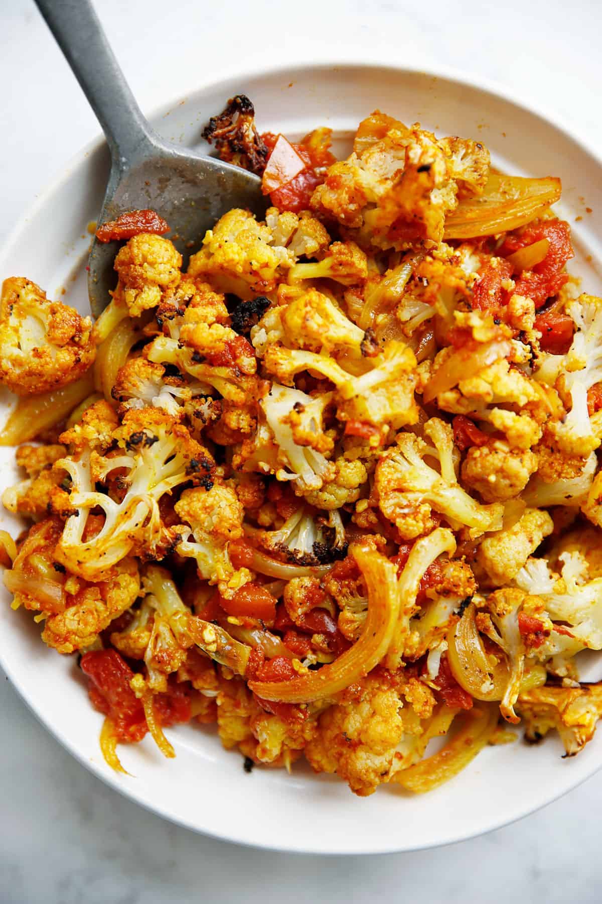 A bowl of spiced roasted cauliflower and onions.