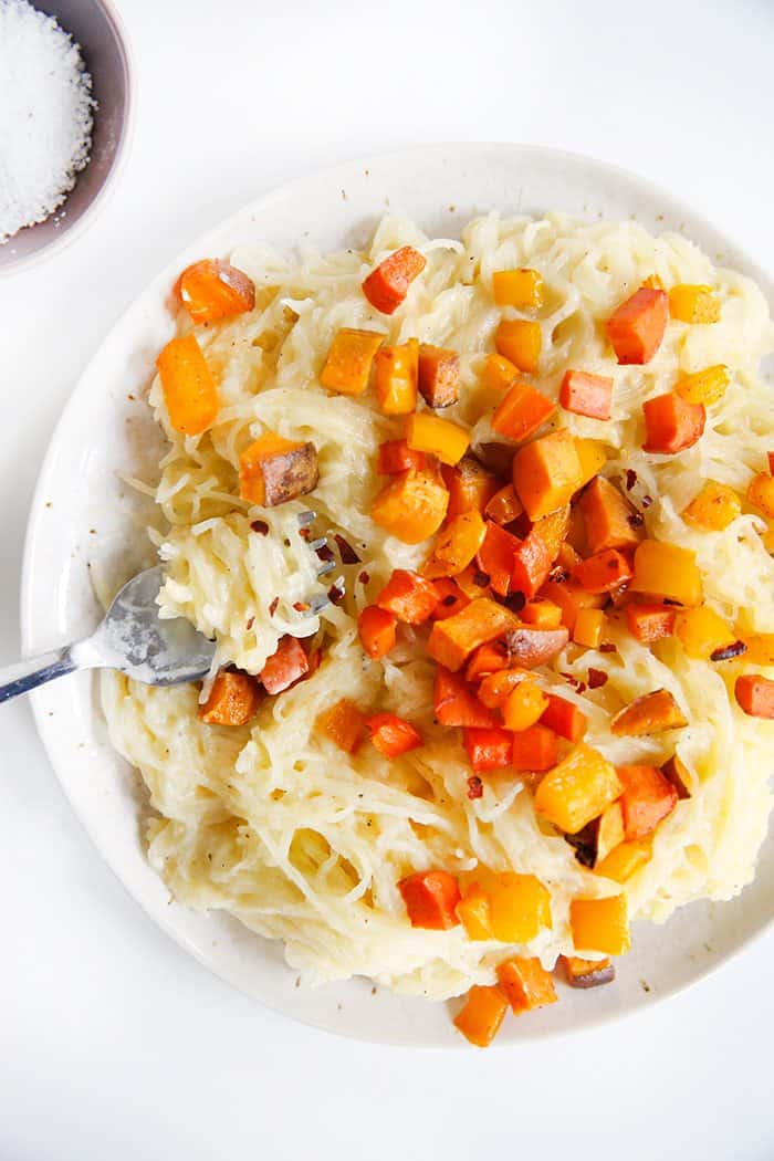 Pasta with Cauliflower Alfredo on a plate with squash on top.