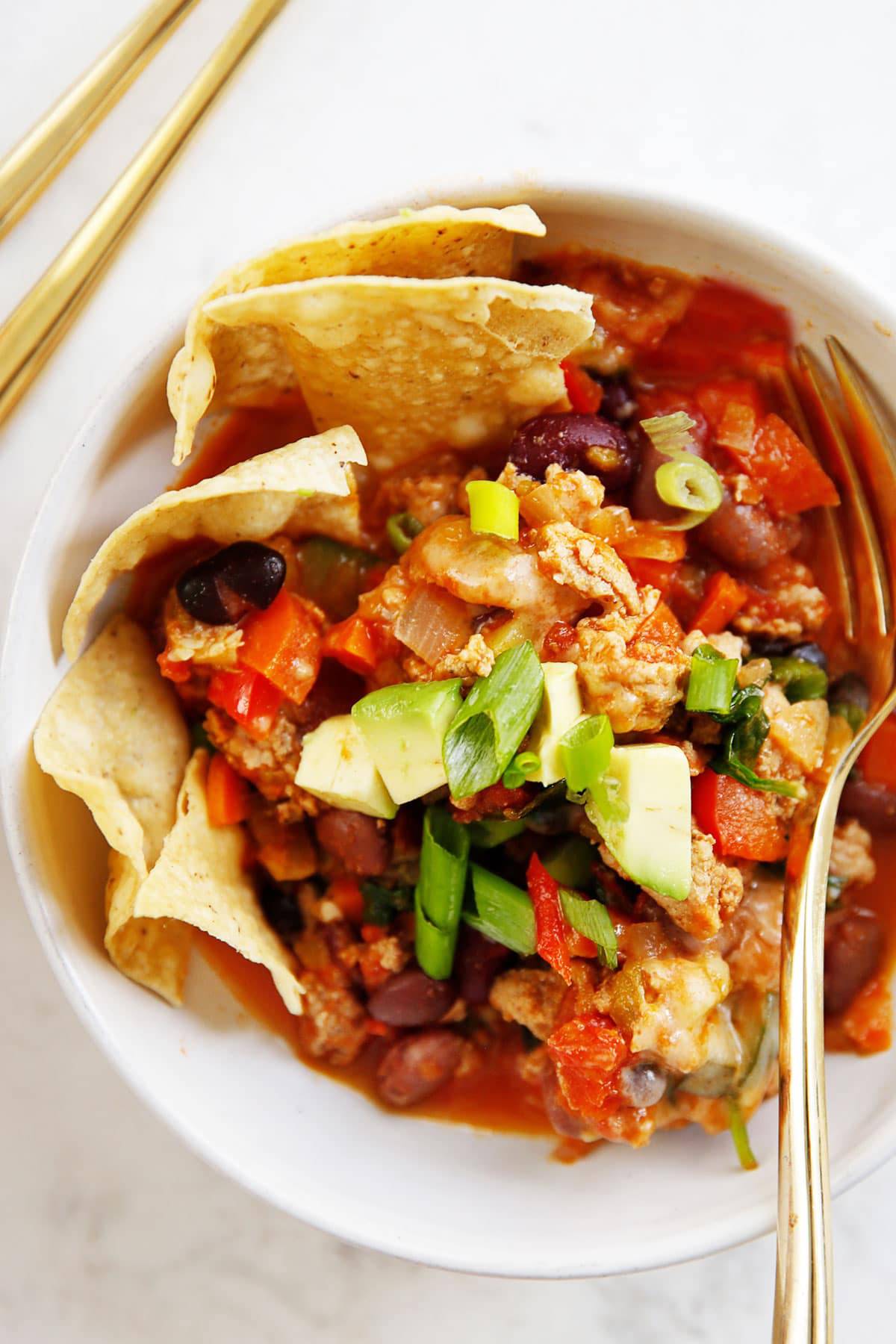 A serving of taco skillet with chips and avocado.