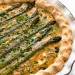 A spring vegetable quiche layered with whole asparagus spears.