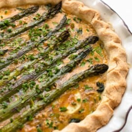 A spring vegetable quiche layered with whole asparagus spears.