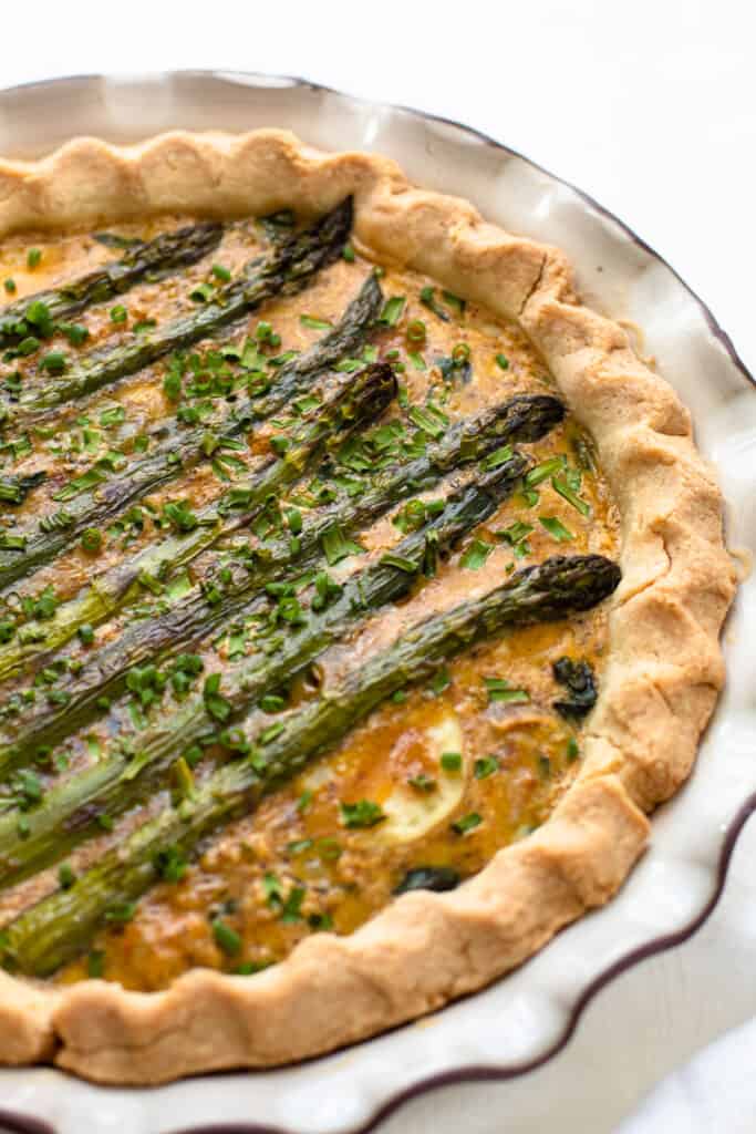 A spring vegetable quiche layered with whole asparagus spears.