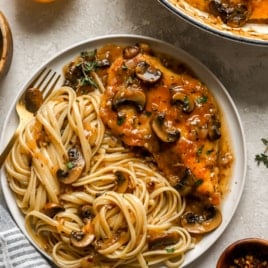 overhead of a plate filled with chicken marsala and spaghetti noodles.