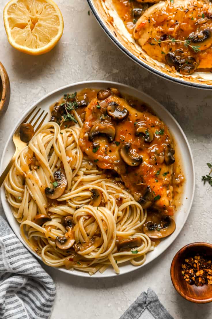 overhead of a plate filled with chicken marsala and spaghetti noodles.