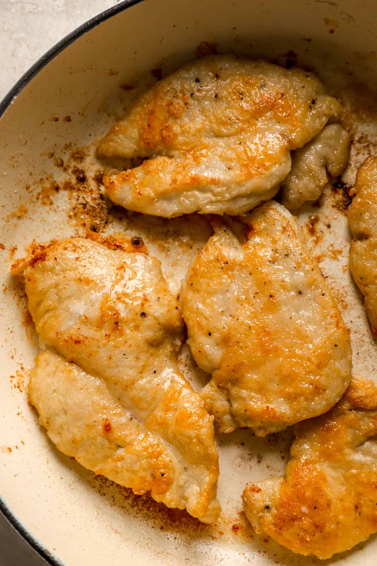pan-fried chicken cutlets in a skillet pan.
