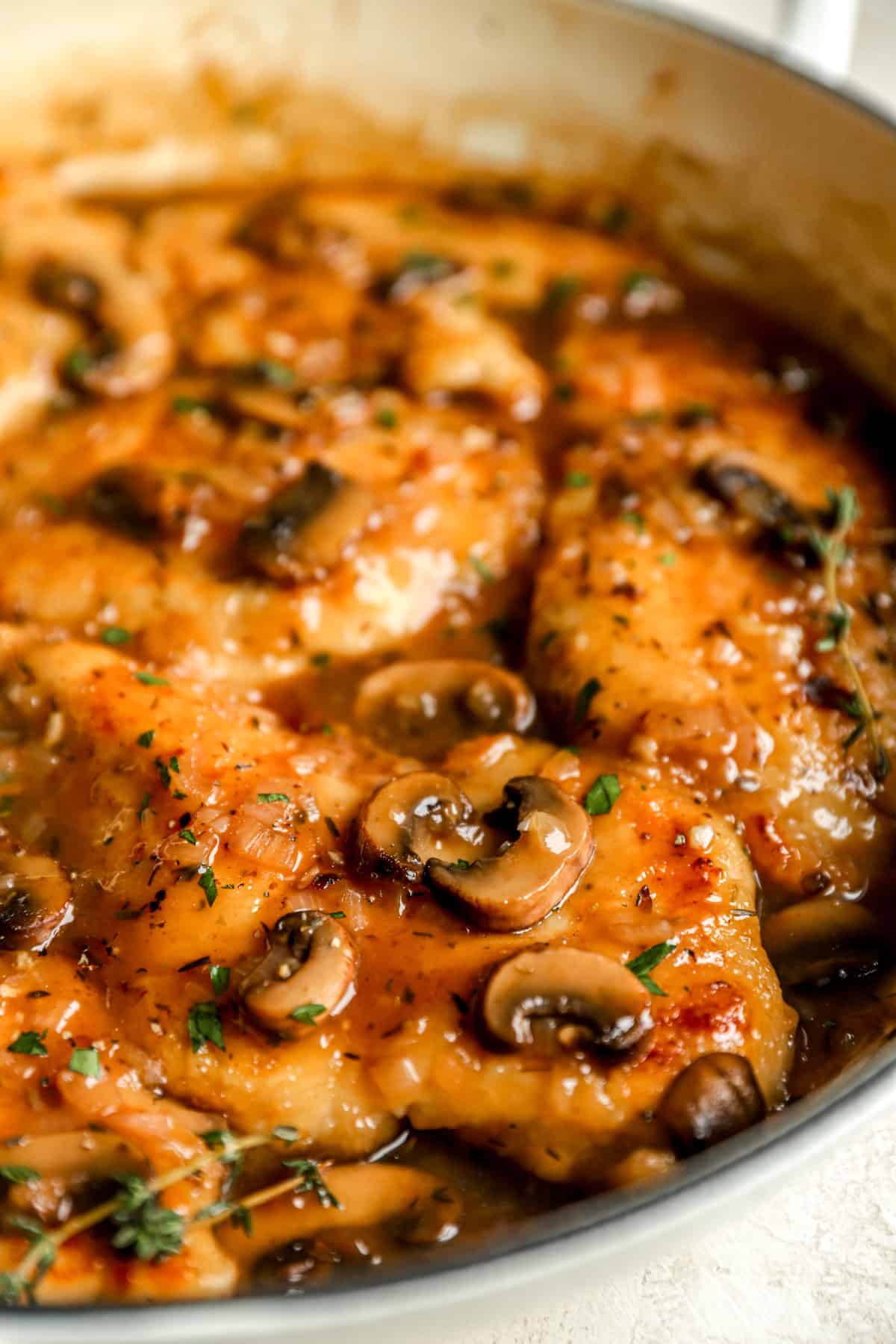 closeup of chicken marsala topped with mushrooms.
