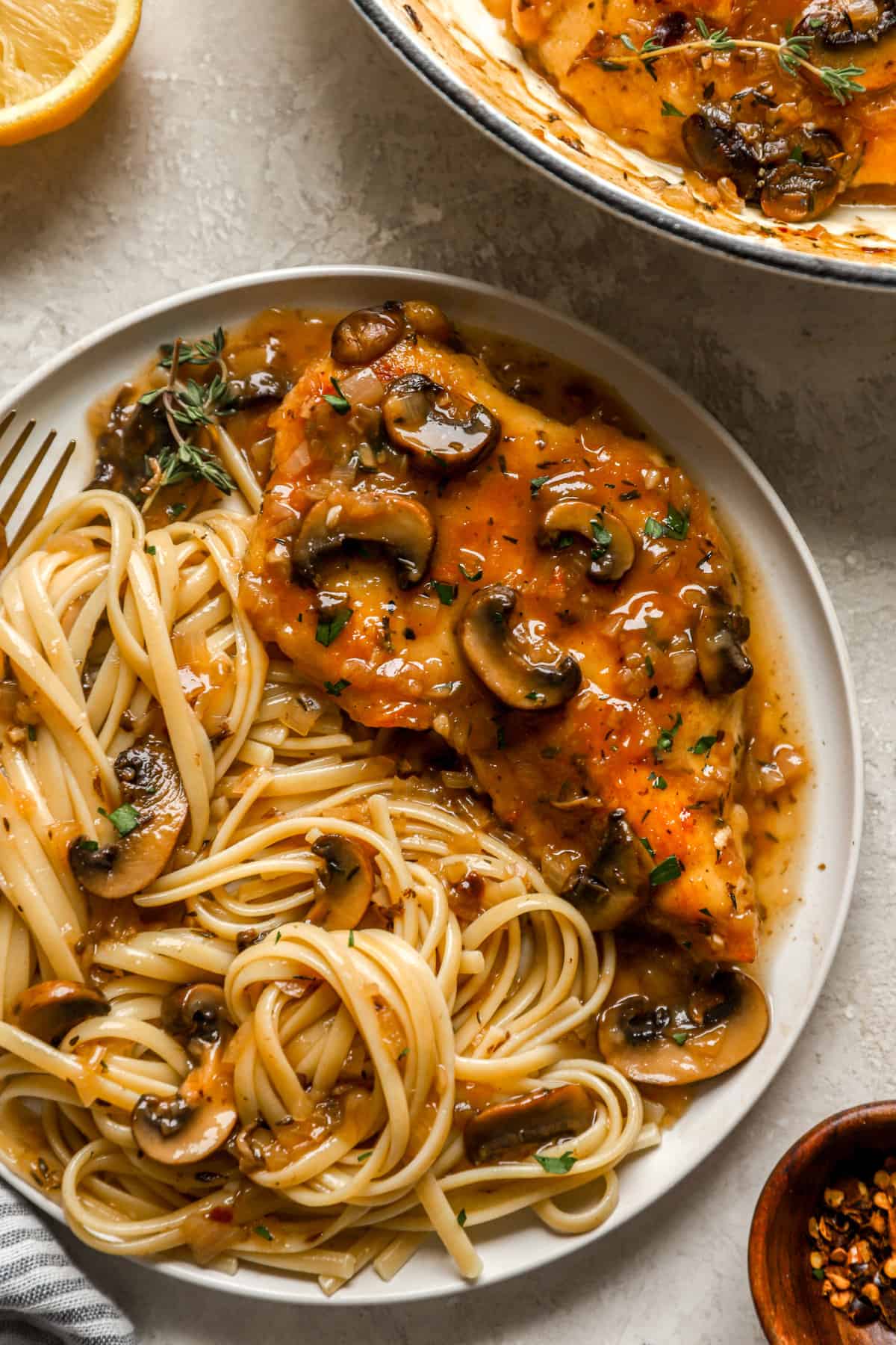 above image and closeup of a plate filled with chicken marsala and spaghetti noodles.