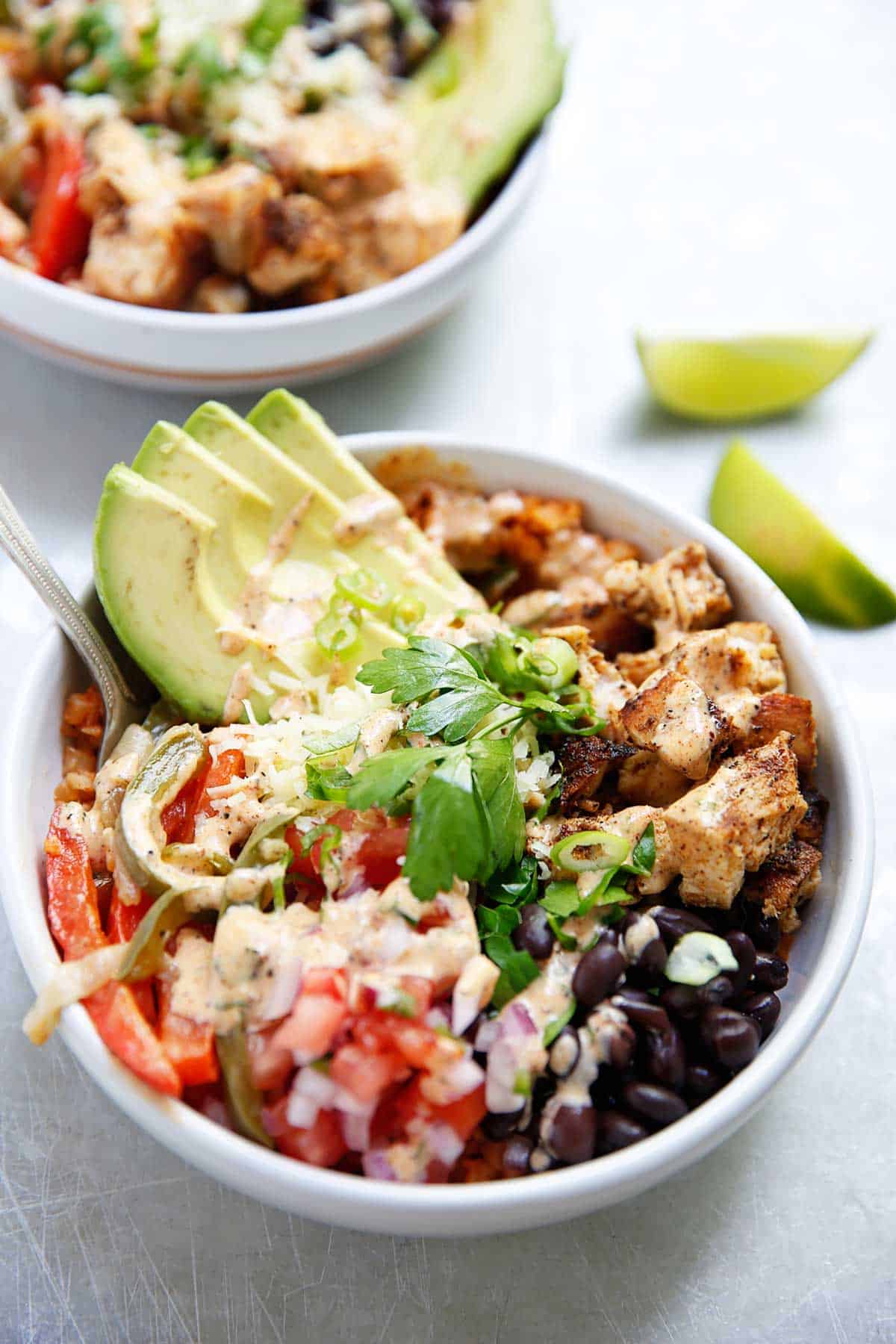 assembled chipotle chicken burrito bowl topped with cilantro and avocado.