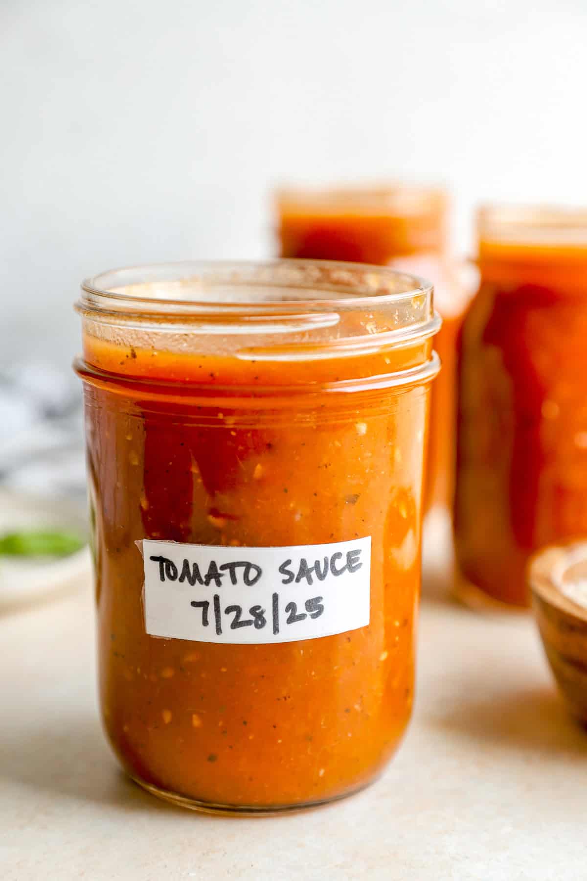 Tomato sauce stored in a mason jar on a ocunter top.