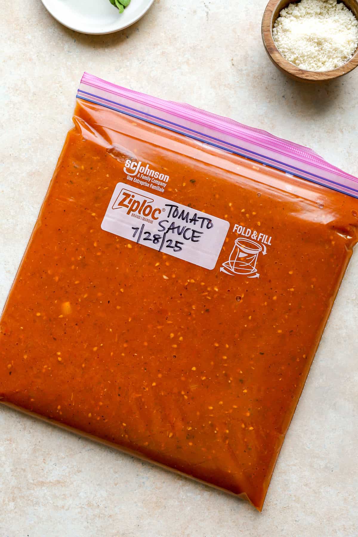 A freezer safe gallon ziploc bag filled with tomato sauce and labeled tomato sauce. 