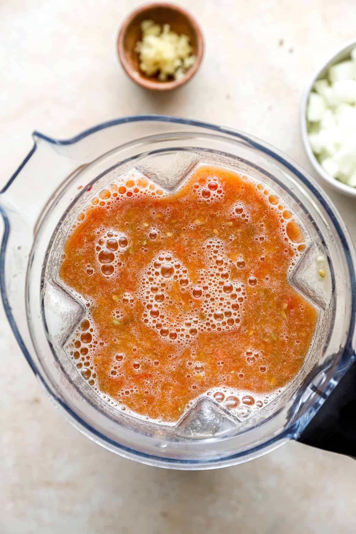 a blender with blended tomatoes looking in from the top.