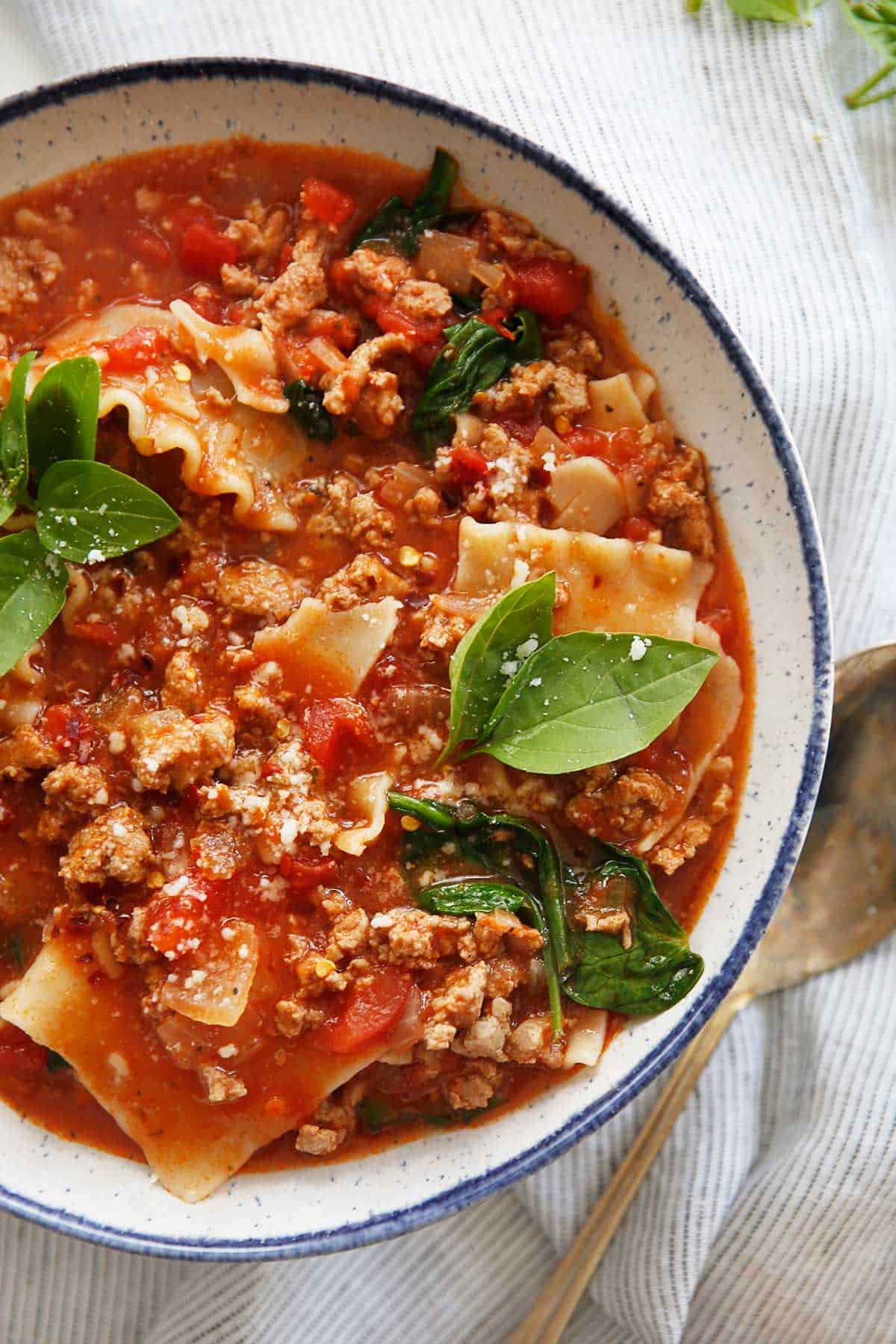 One-Pot Lasagna Soup made with gluten-free nooldles and garnished with basil 