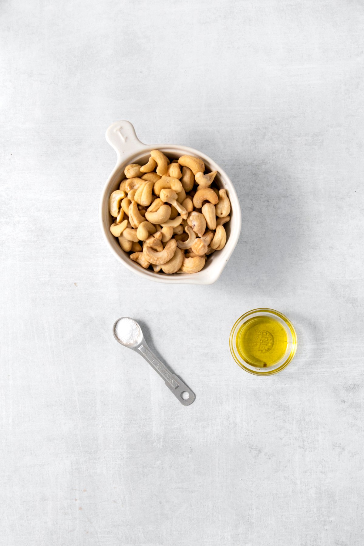 cashews, oil, and salt on a work surface.