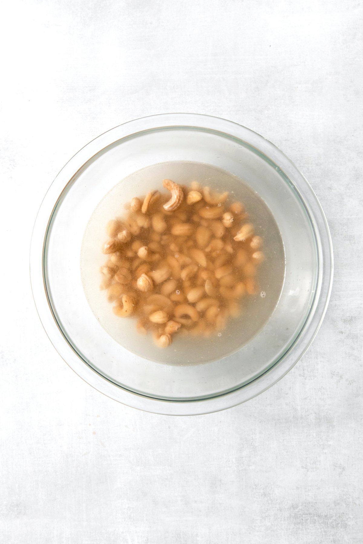 cashews being soaked in a bowl of water.