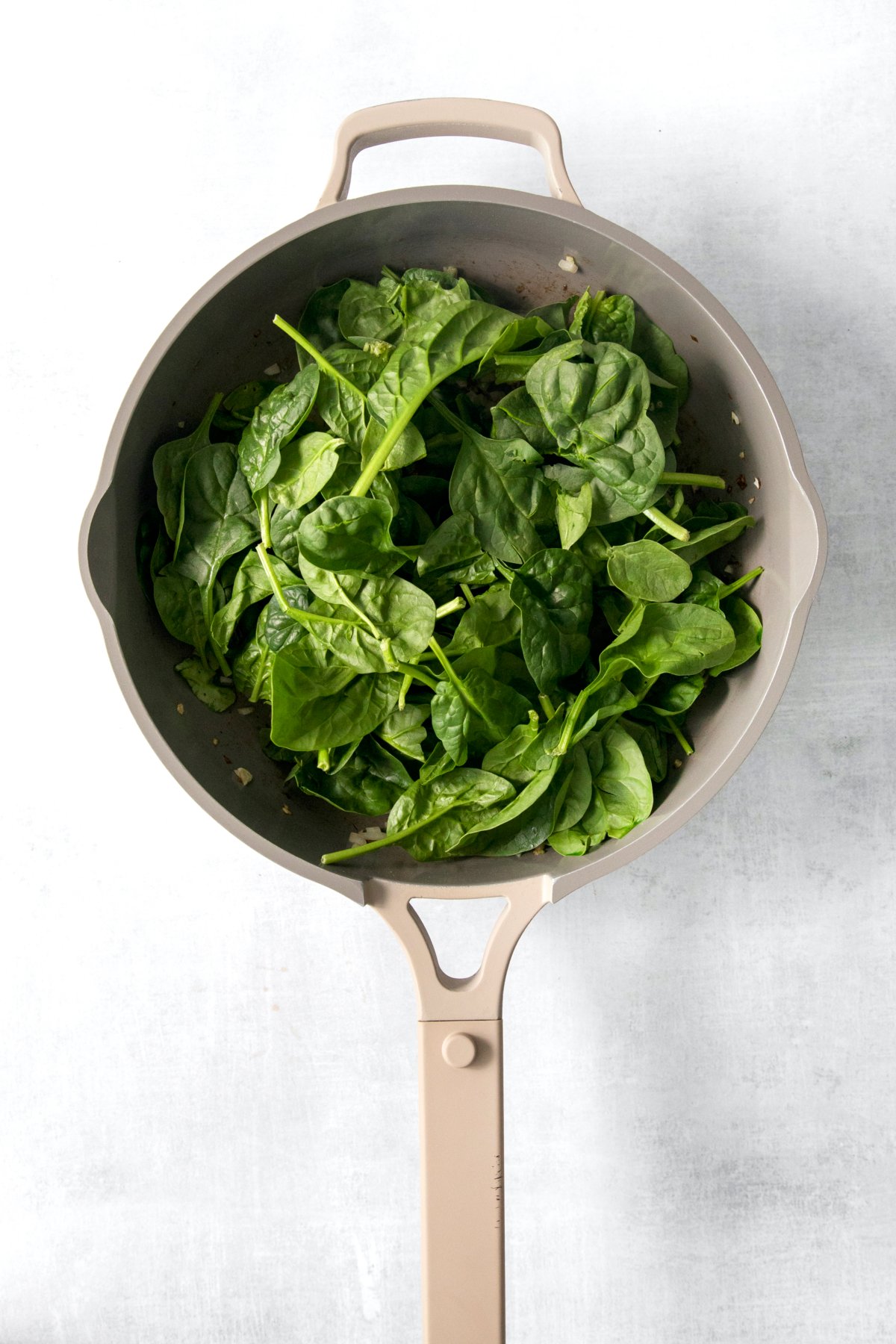 fresh spinach in a skillet.