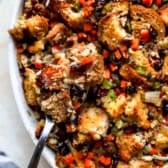 Gluten-Free Stuffing in a white serving bowl with a silver spoon.