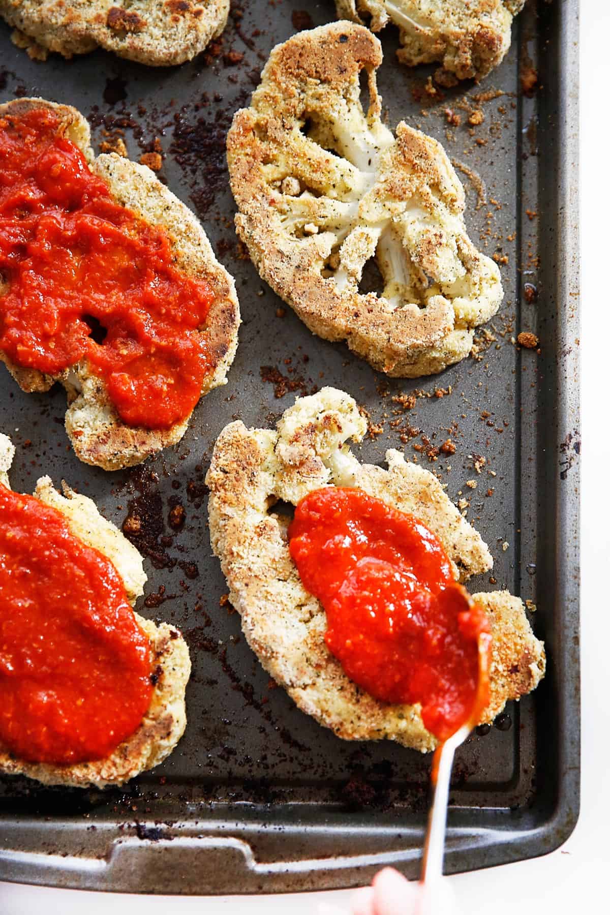 above image of cauliflower steaks topped with marinara.