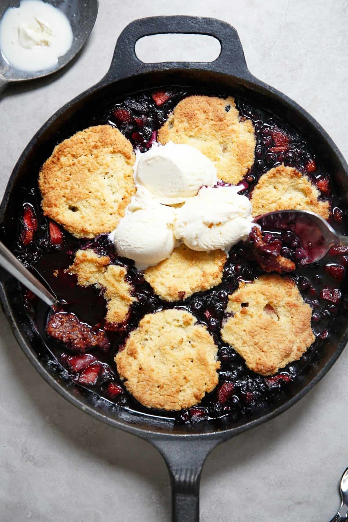Mixed Berry Cobbler in a skillet with ice cream