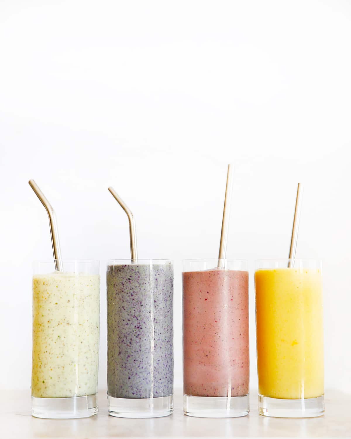 Four different colorful smoothies.