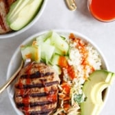 overhead shot of a bowl with a turkey burger, rice, slaw, and avocado.
