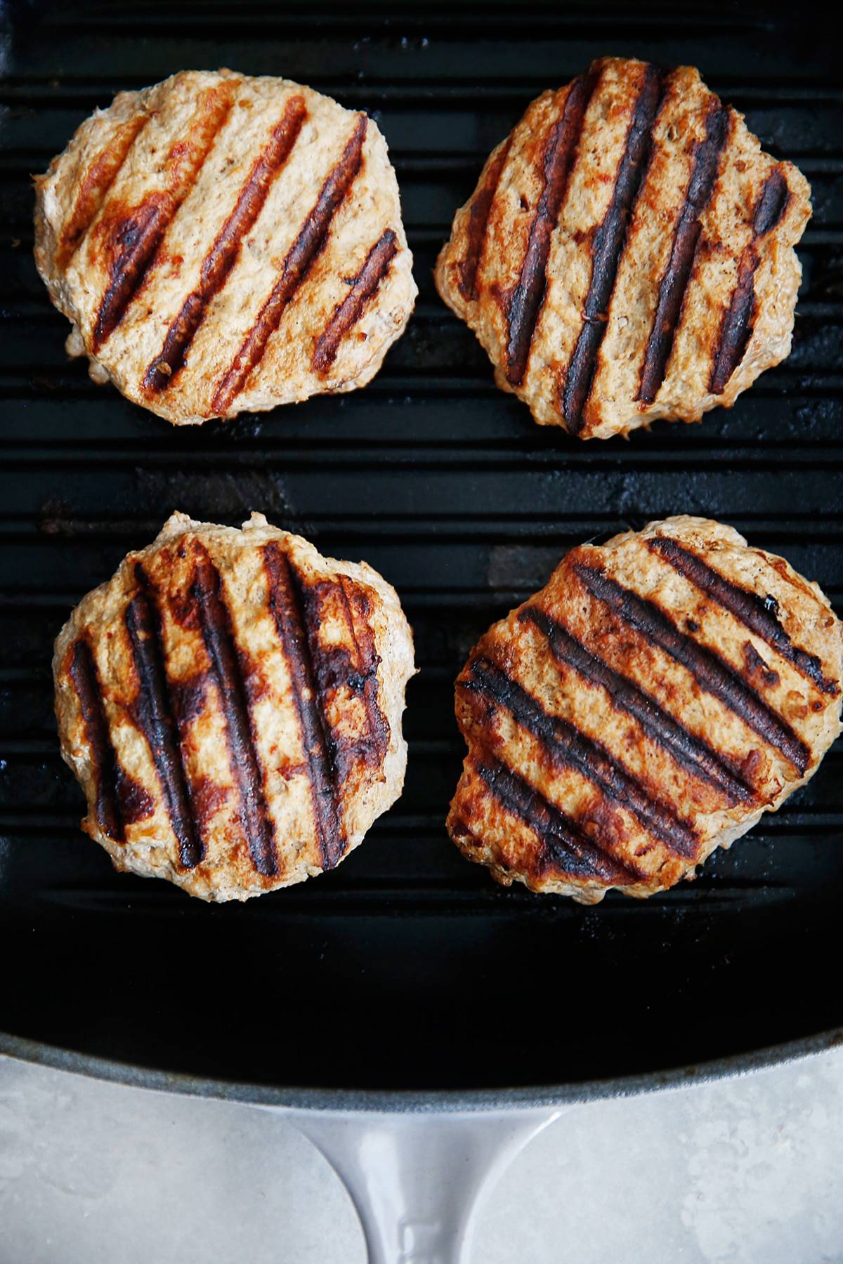 four turkey burgers on a grill pan.