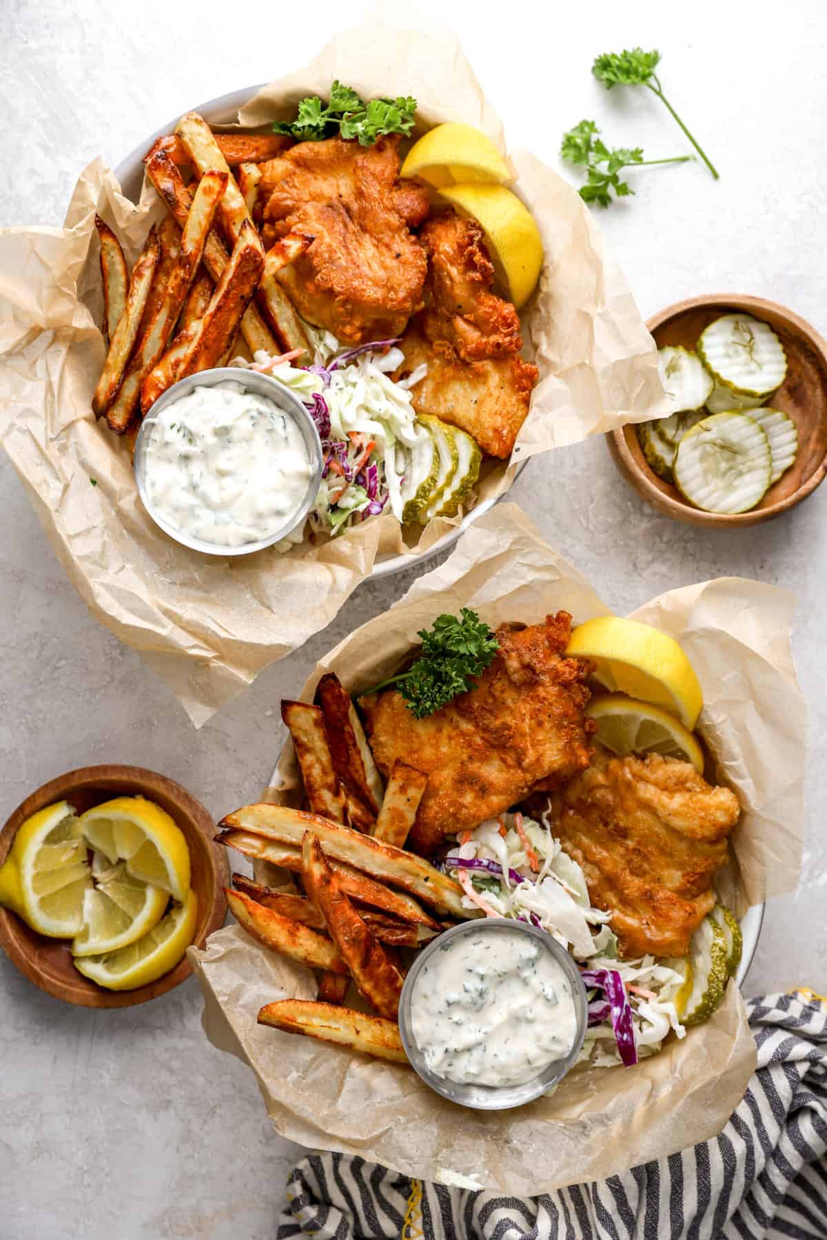 Two baskets of paleo fish and chips with coleslaw and tartar sauce.