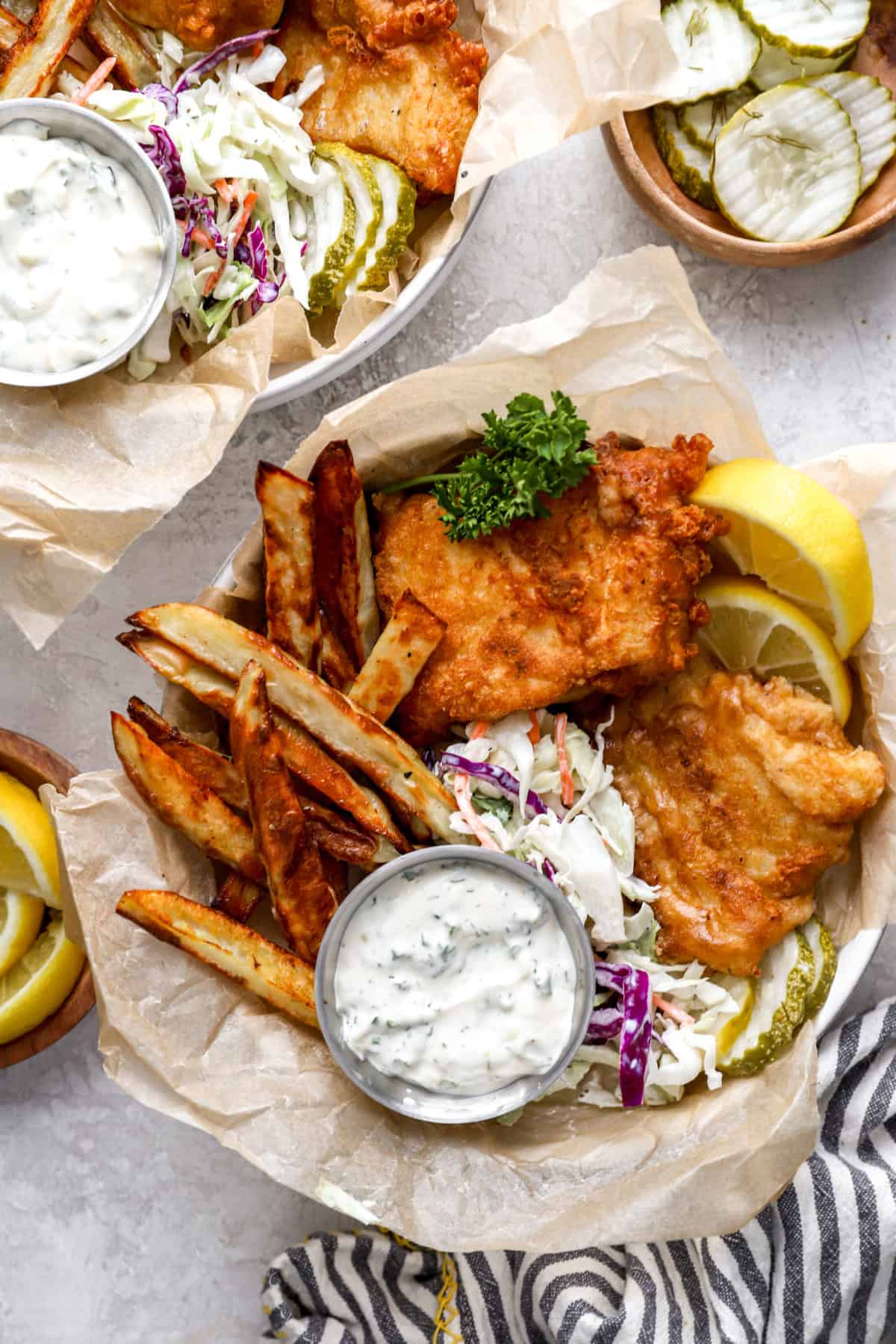 A basket of homemade fish and chips with slaw and tartar sauce. 