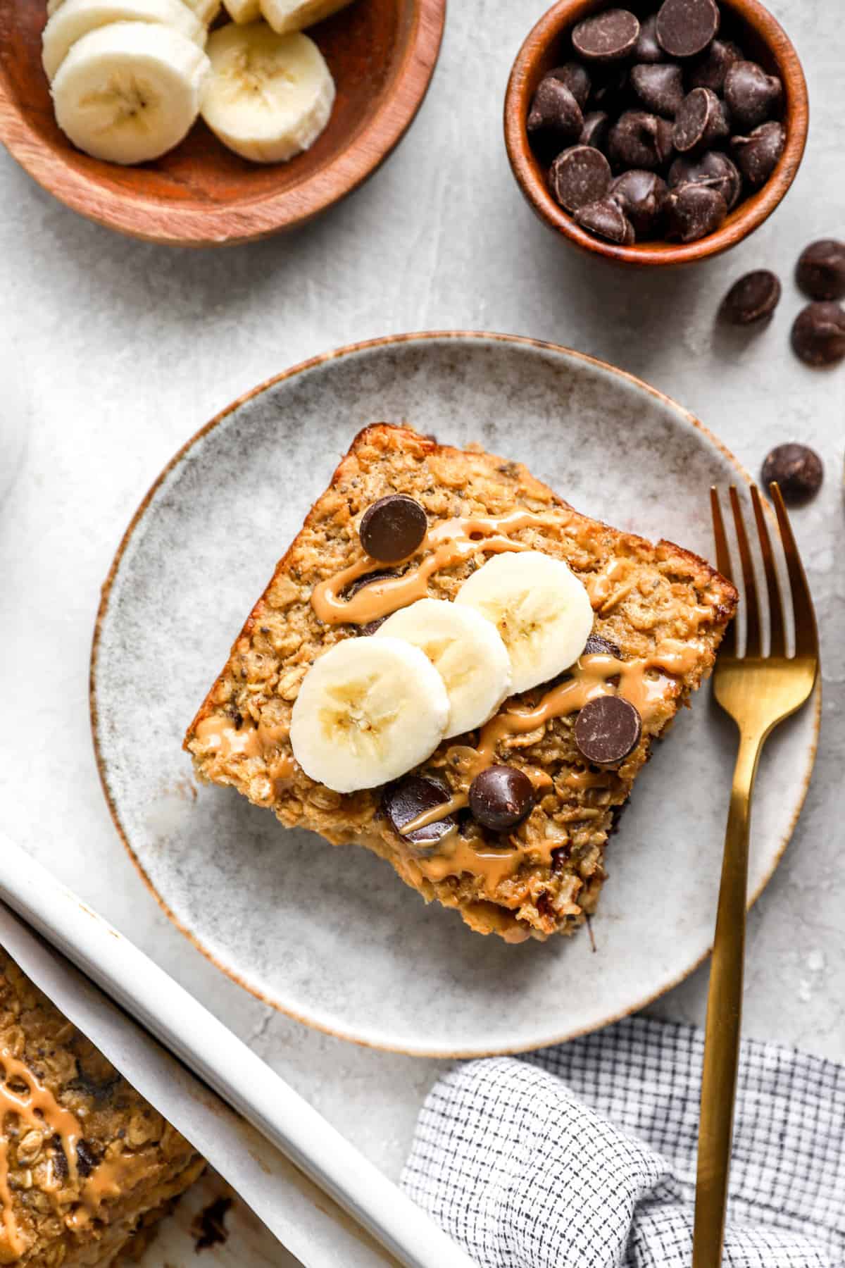 a square of banana baked oatmeal topped with slices of banana from above. 