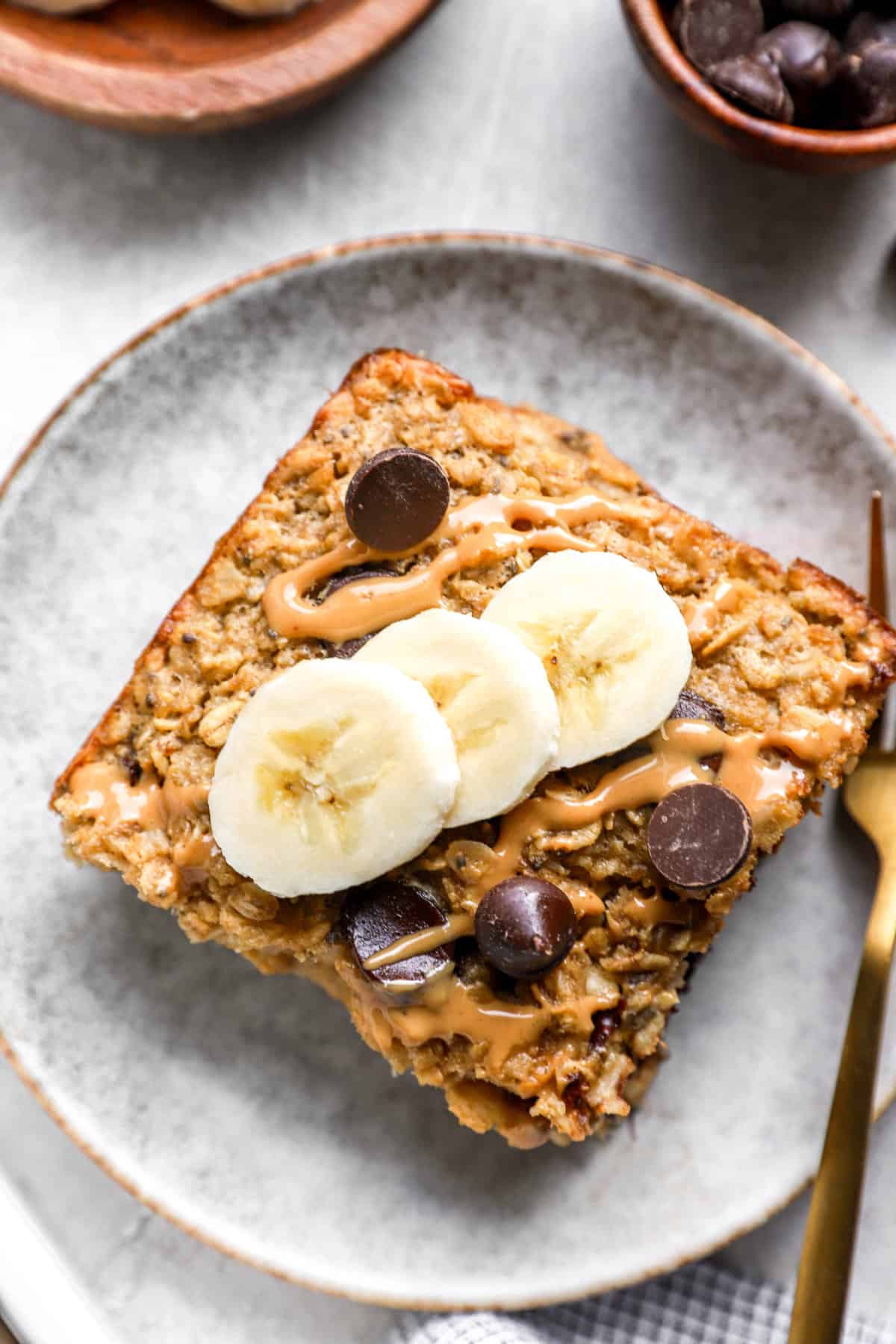 a square of banana baked oatmeal topped with slices of banana from above.