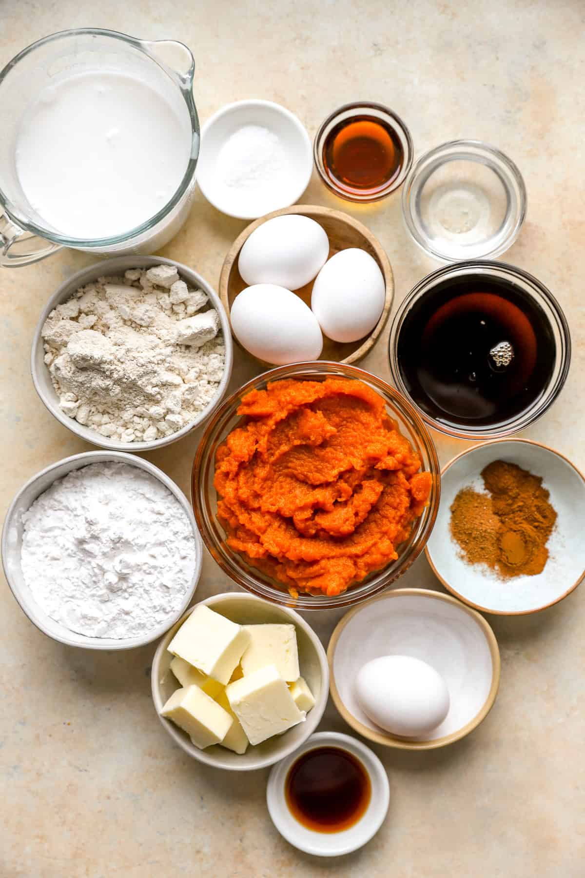 All pumpkin pie ingredients laid our in bowls on the counter top.