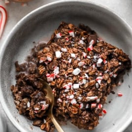 above image of a slice of chocolate peppermint baked oatmeal in a bowl with a spoon.