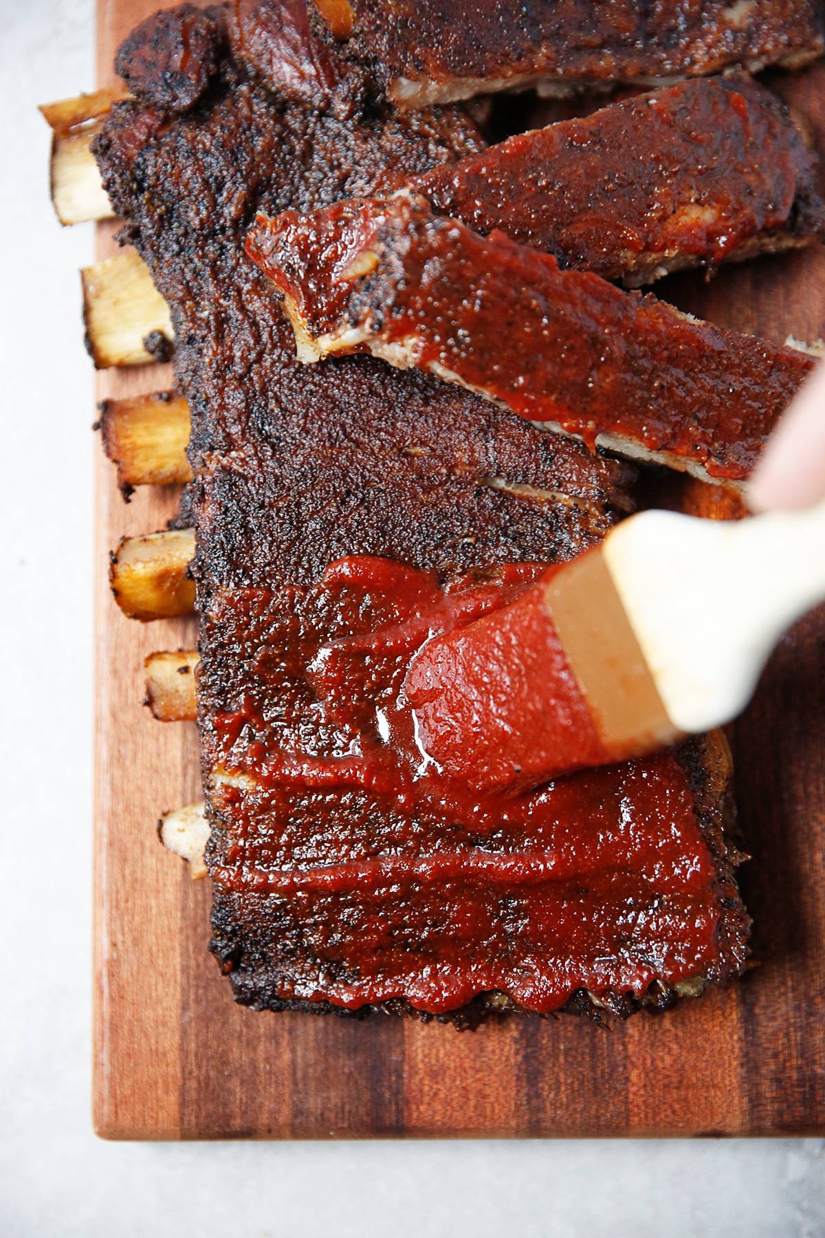 Homemade barbecue Sauce being brushed on ribs