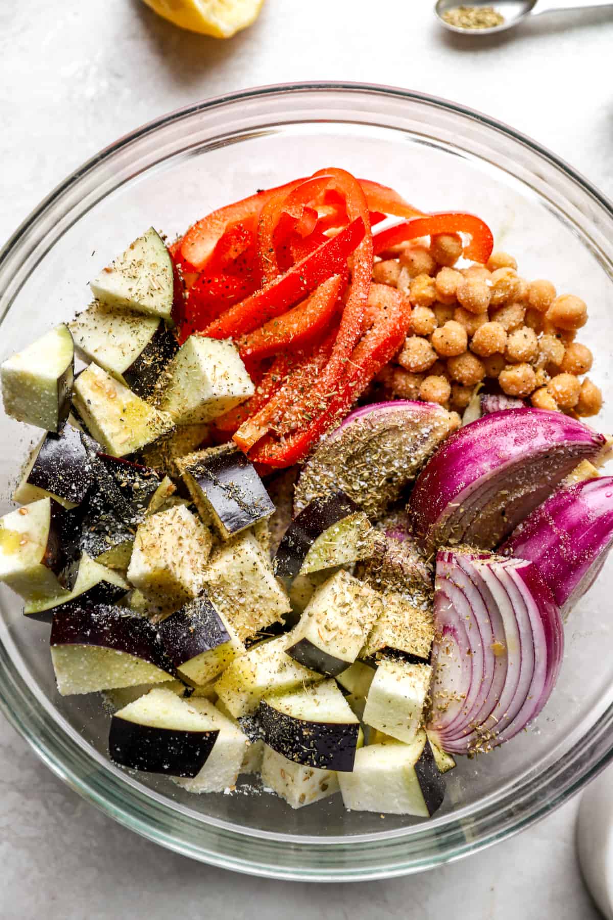 above image of a bowl filled with chopped eggplant, red onion, and red bell pepper.