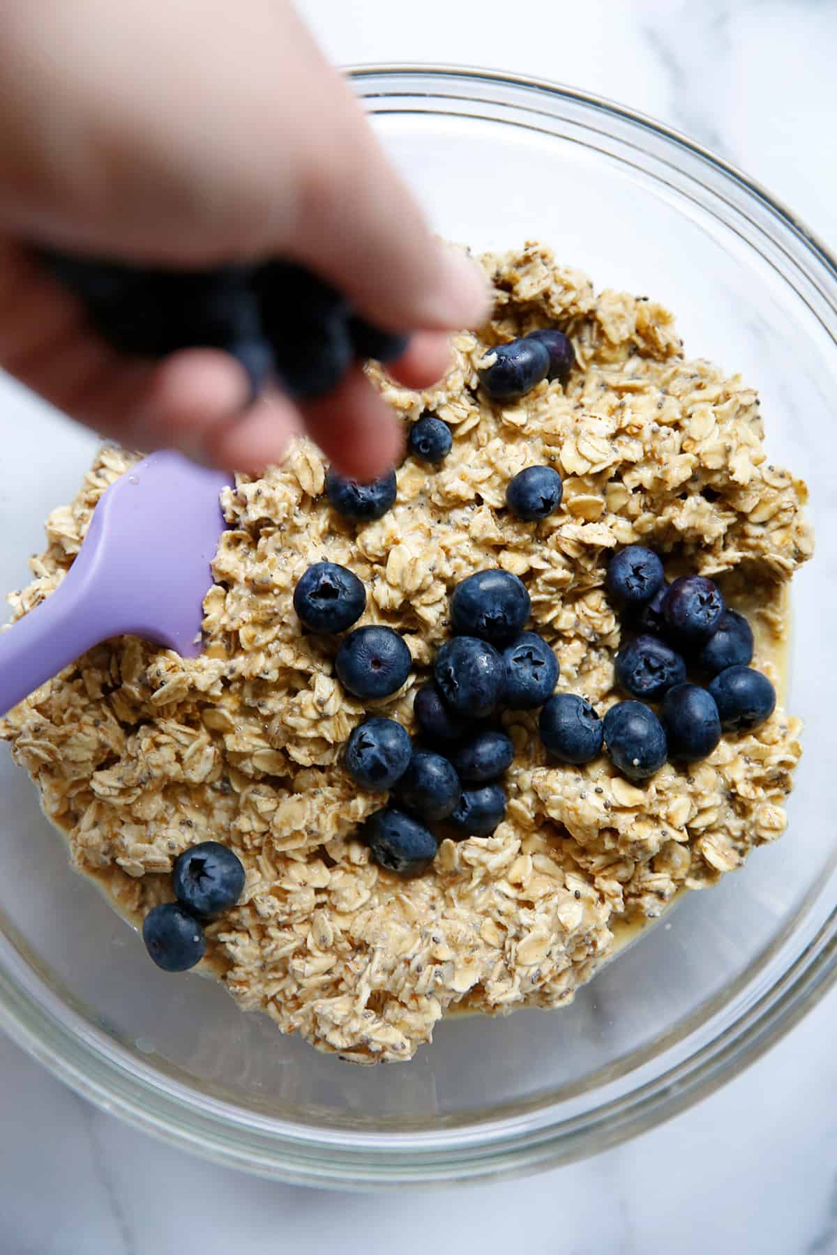 Putting blueberries inside of the bowl with oats