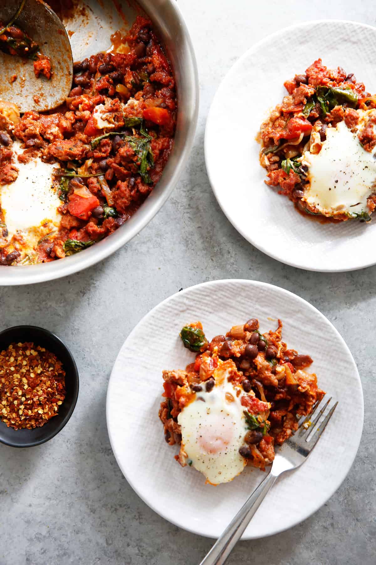 Two portions baked eggs and chorizo on a plate.