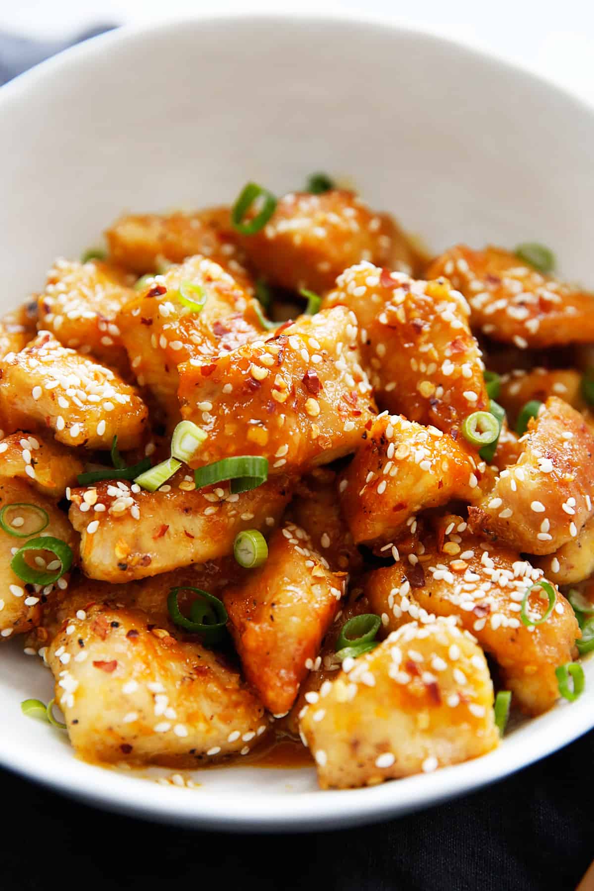 Healthy orange chicken in a bowl with garnish