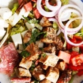 A bowl of chopped antipasto salad with chicken.