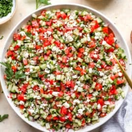 Finally chopped tomato, cucumber and onion tossed together in a big white bowl for serving.