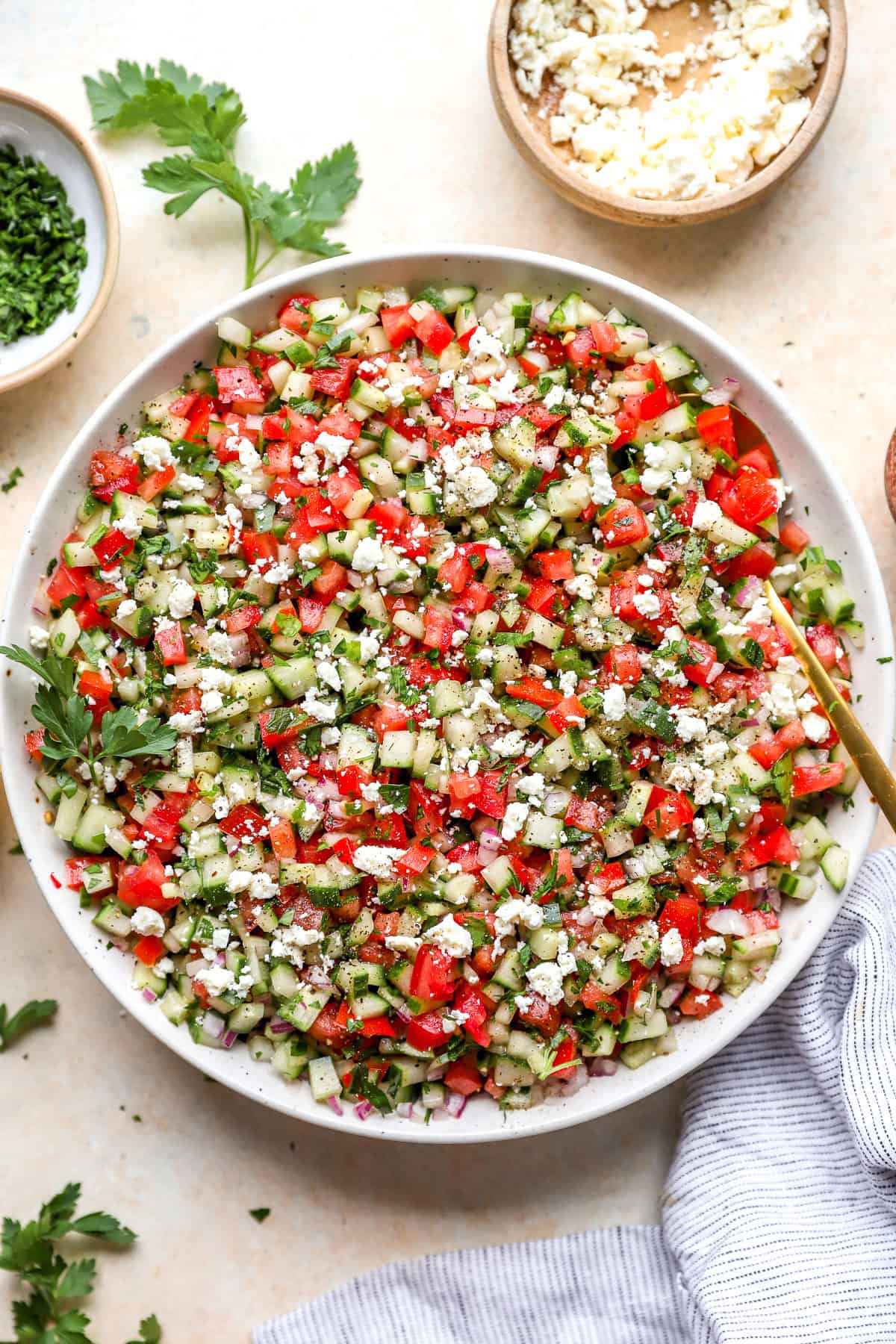 Finally chopped tomato, cucumber and onion tossed together in a big white bowl for serving.
