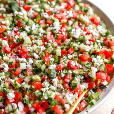Finally chopped tomato, cucumber and onion tossed together in a big white bowl for serving.