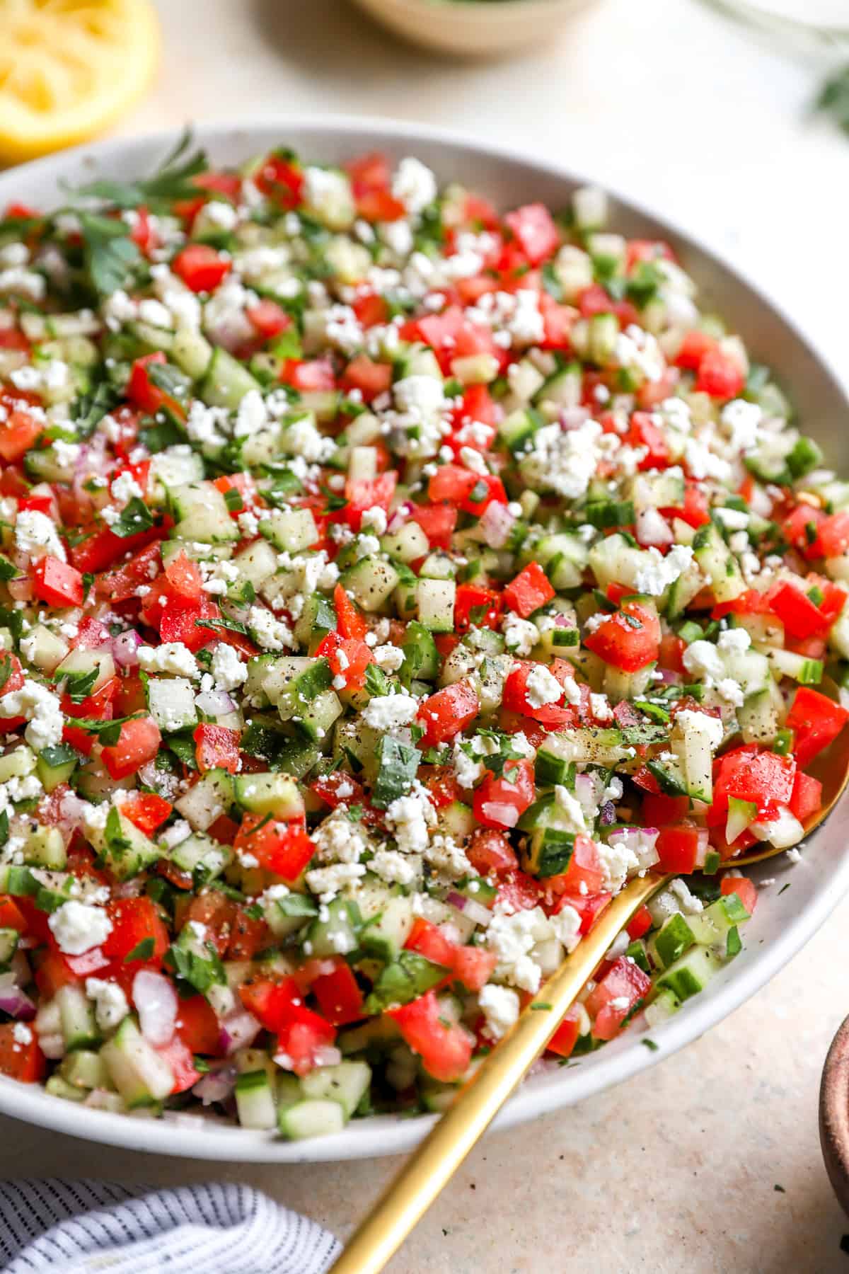 Finally chopped tomato, cucumber and onion tossed together in a big white bowl for serving.