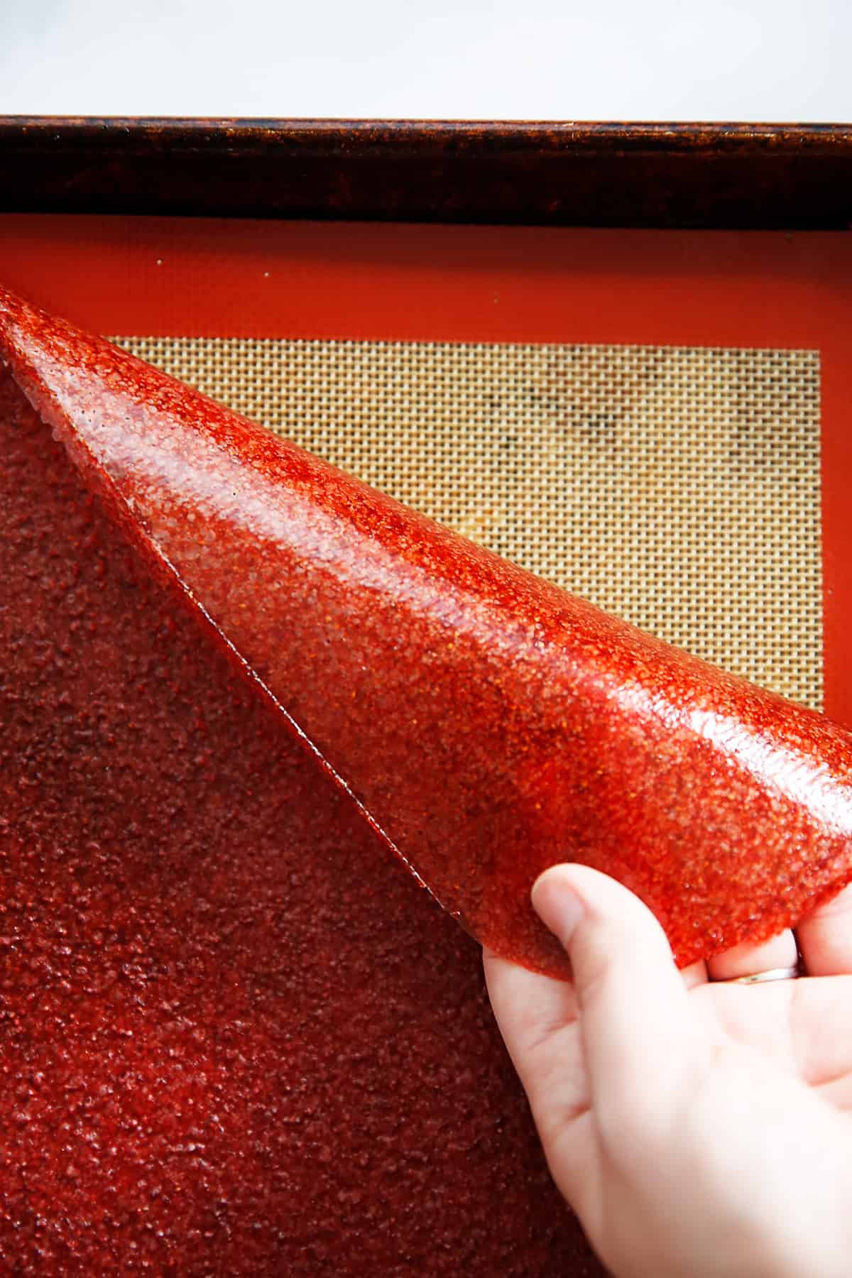 Homemade strawberry fruit leather on a sheet pan.